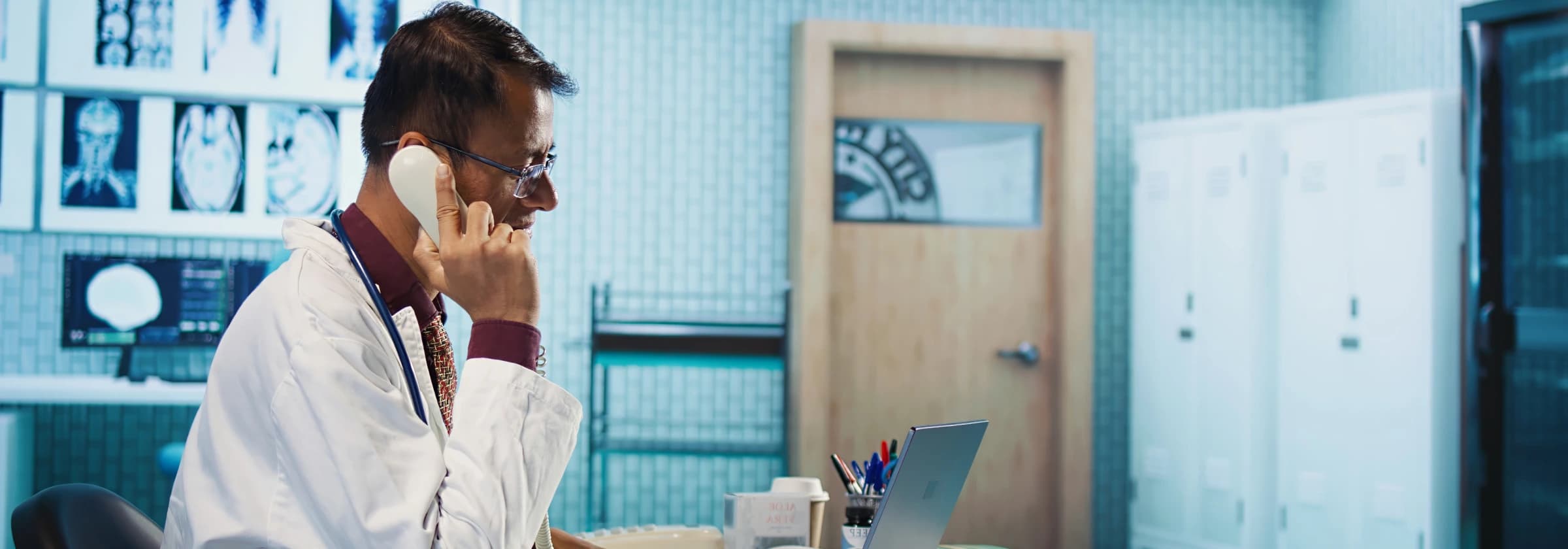 On-call physician taking a phone call at a clinic desk