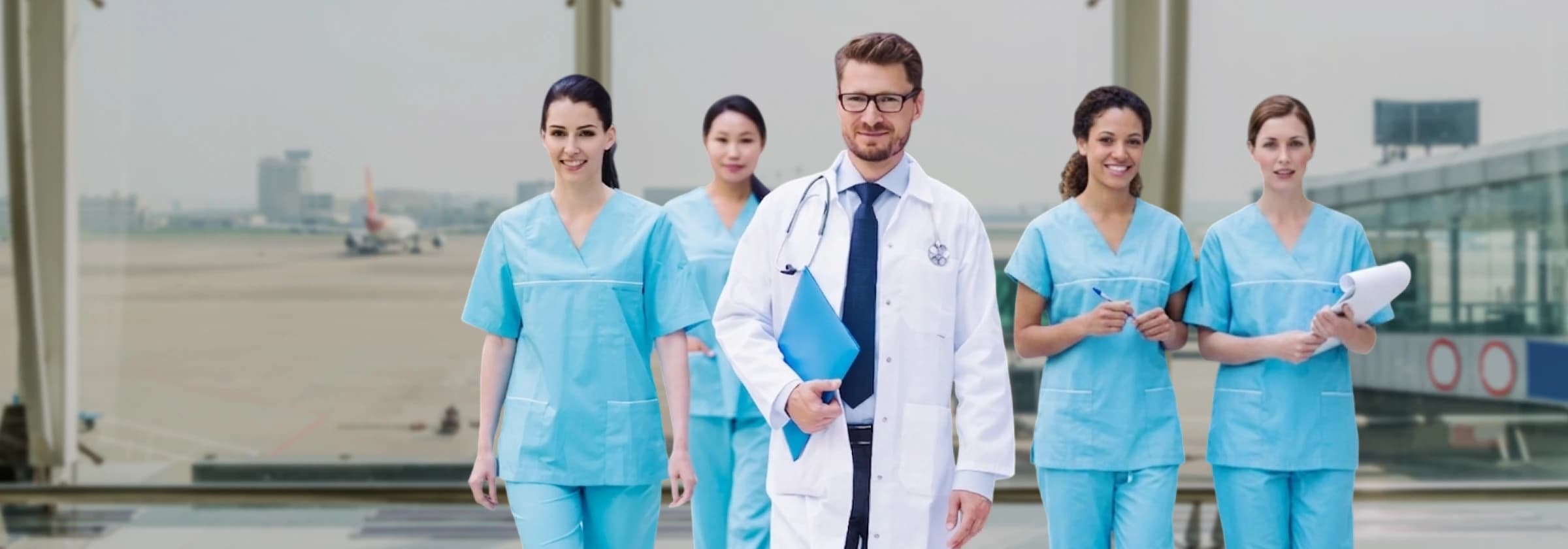 Medical team in scrubs and a physician walking through an airport terminal